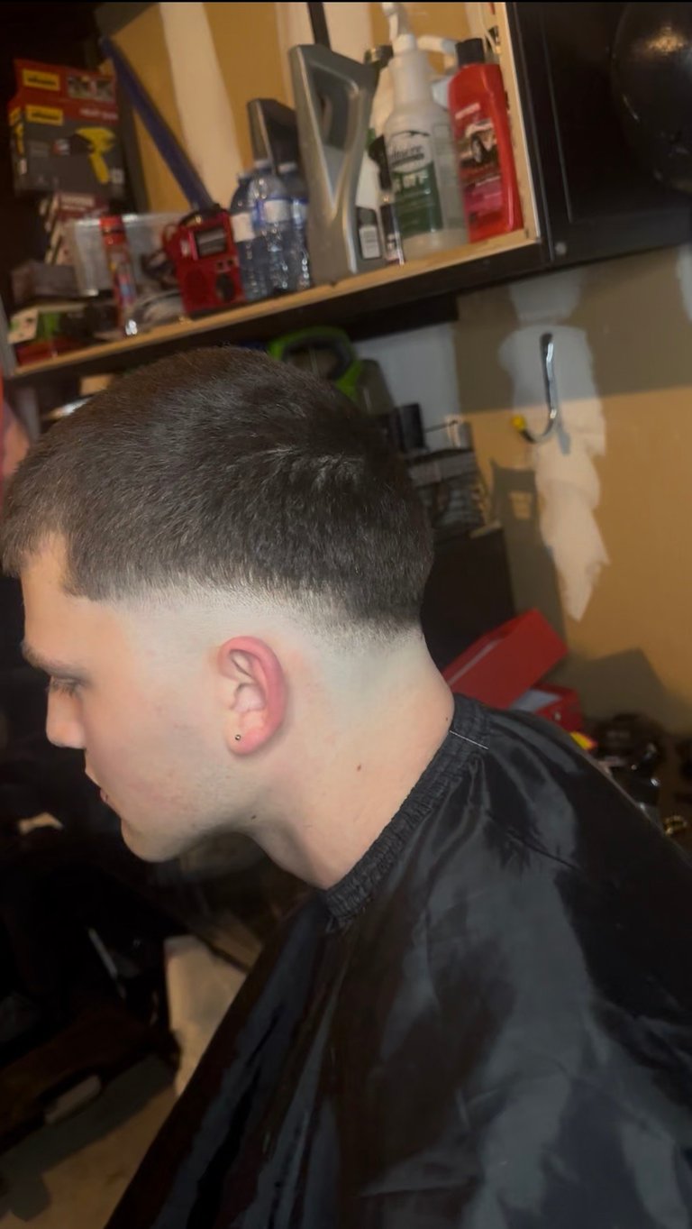 Side profile of person with short fade haircut wearing black shirt